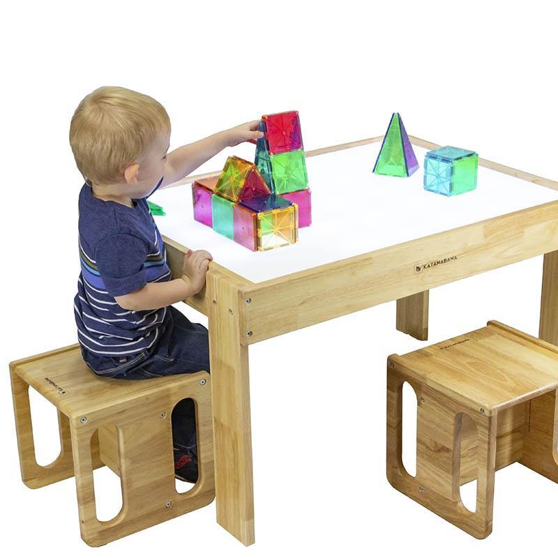 Toddler sitting on a cube chair stool playing with a Montessori kids light table