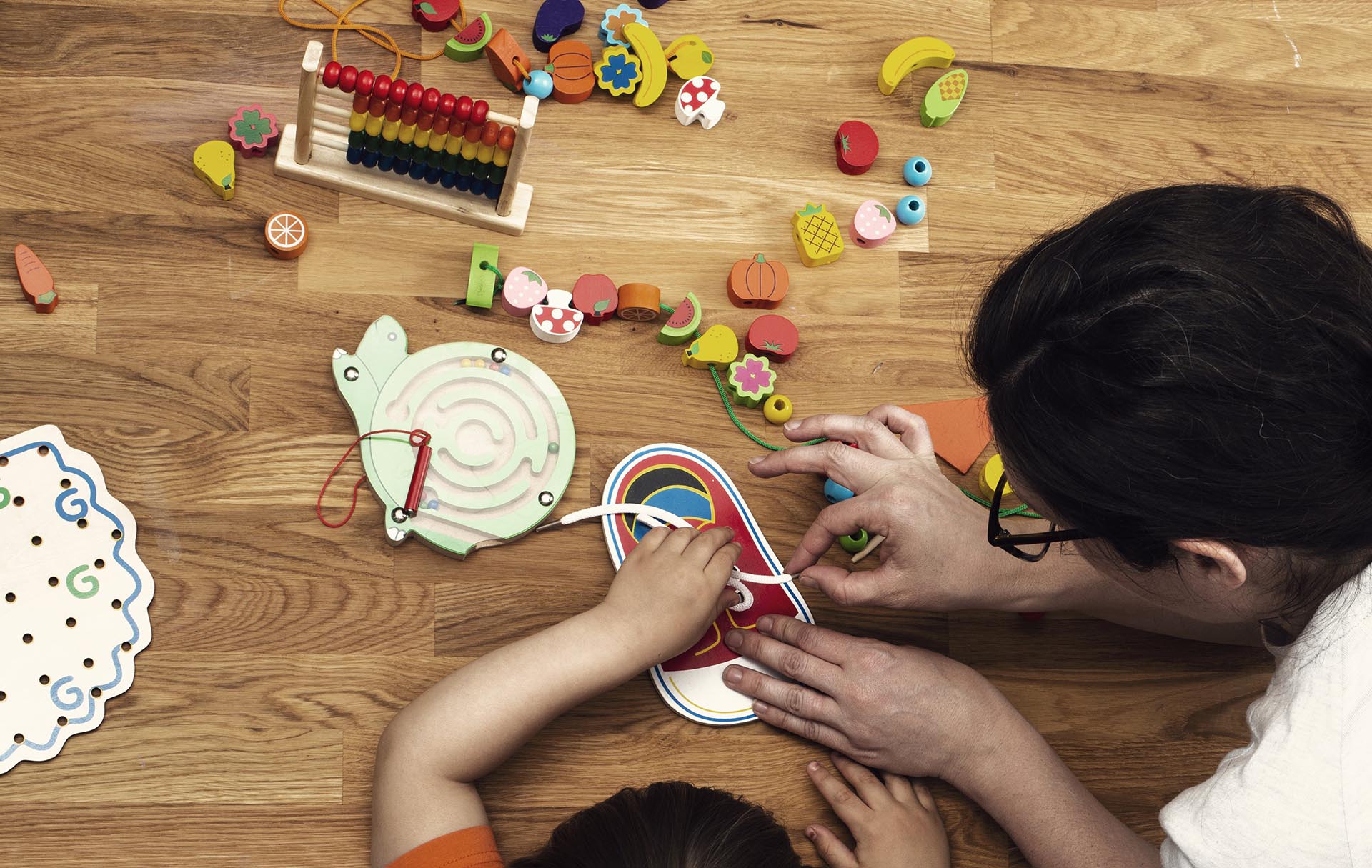 Parent helps kid with Montessori activity