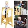Kid standing on learning toddler tower in kitchen cooking